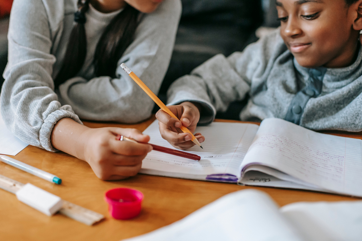 Crop kids doing homework together